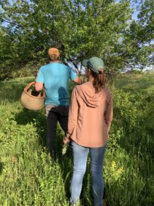 Photo of Krista on a foraging walk on their property with Chef Dyllan, a foraging chef