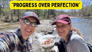 Photo of Krista and Scott eating lunch next to a river with the caption "Progress Over Perfection"